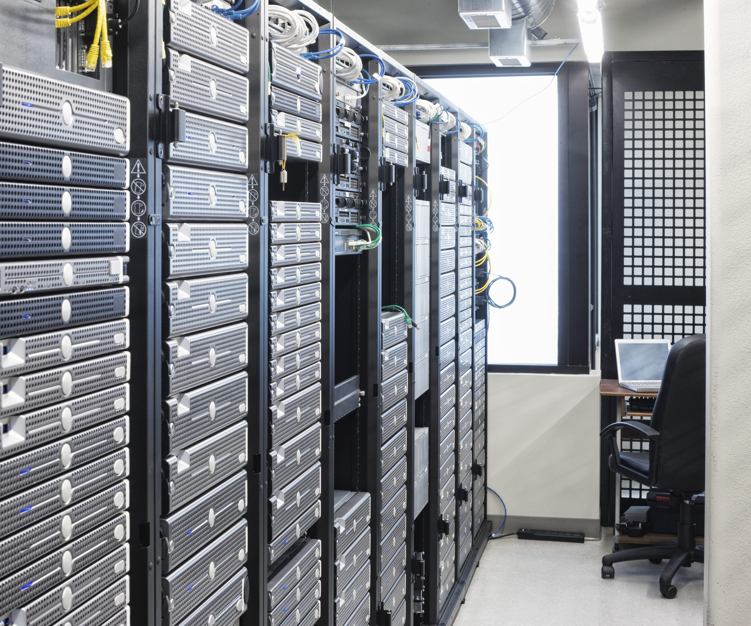 Servers in an aisle of racks in a computer server farm.